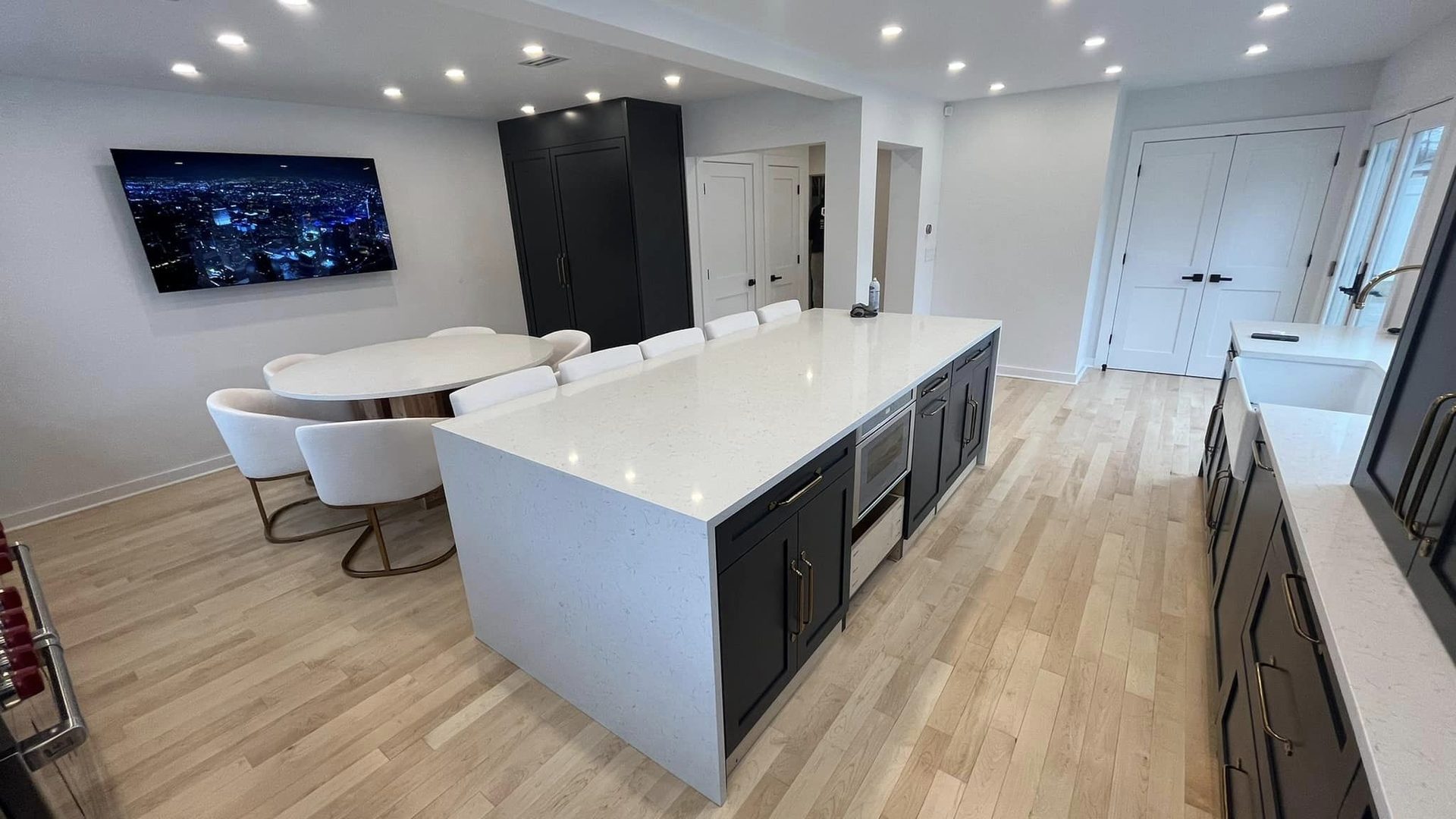 millwork_install_gurskyi_Open kitchen with dark base cabinets and a white quartz waterfall island