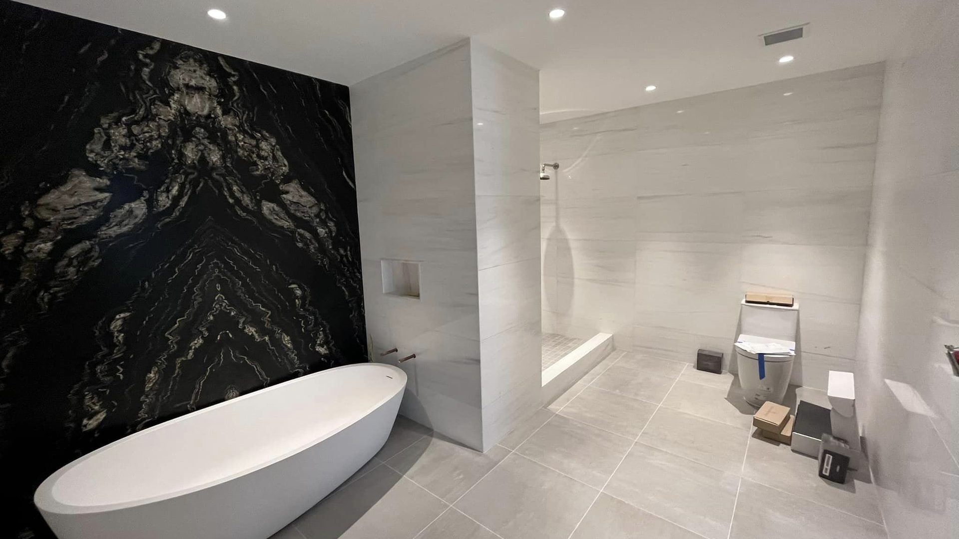 millwork_install_gurskyi_Bathroom with black stone feature wall and freestanding tub
