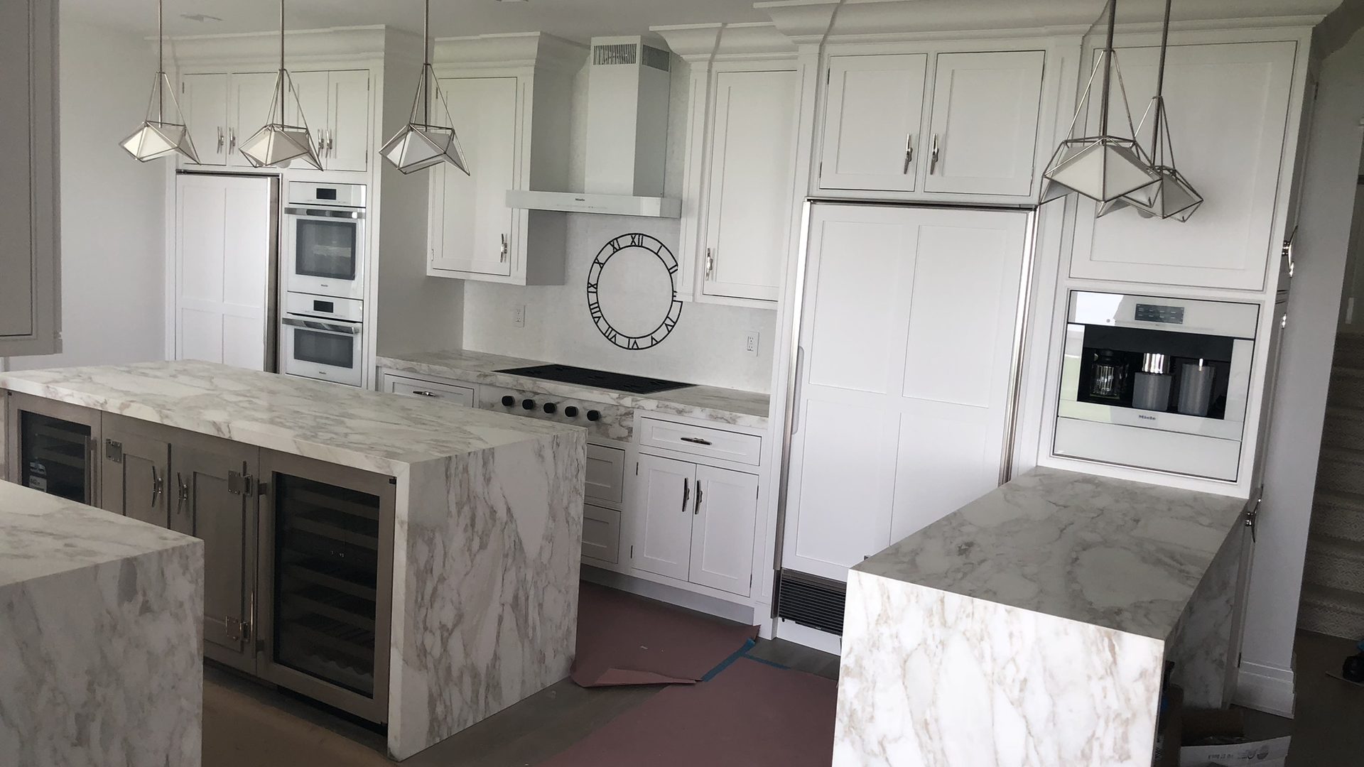 millwork_install_gurskyi_Kitchen with white cabinetry and marble waterfall islands